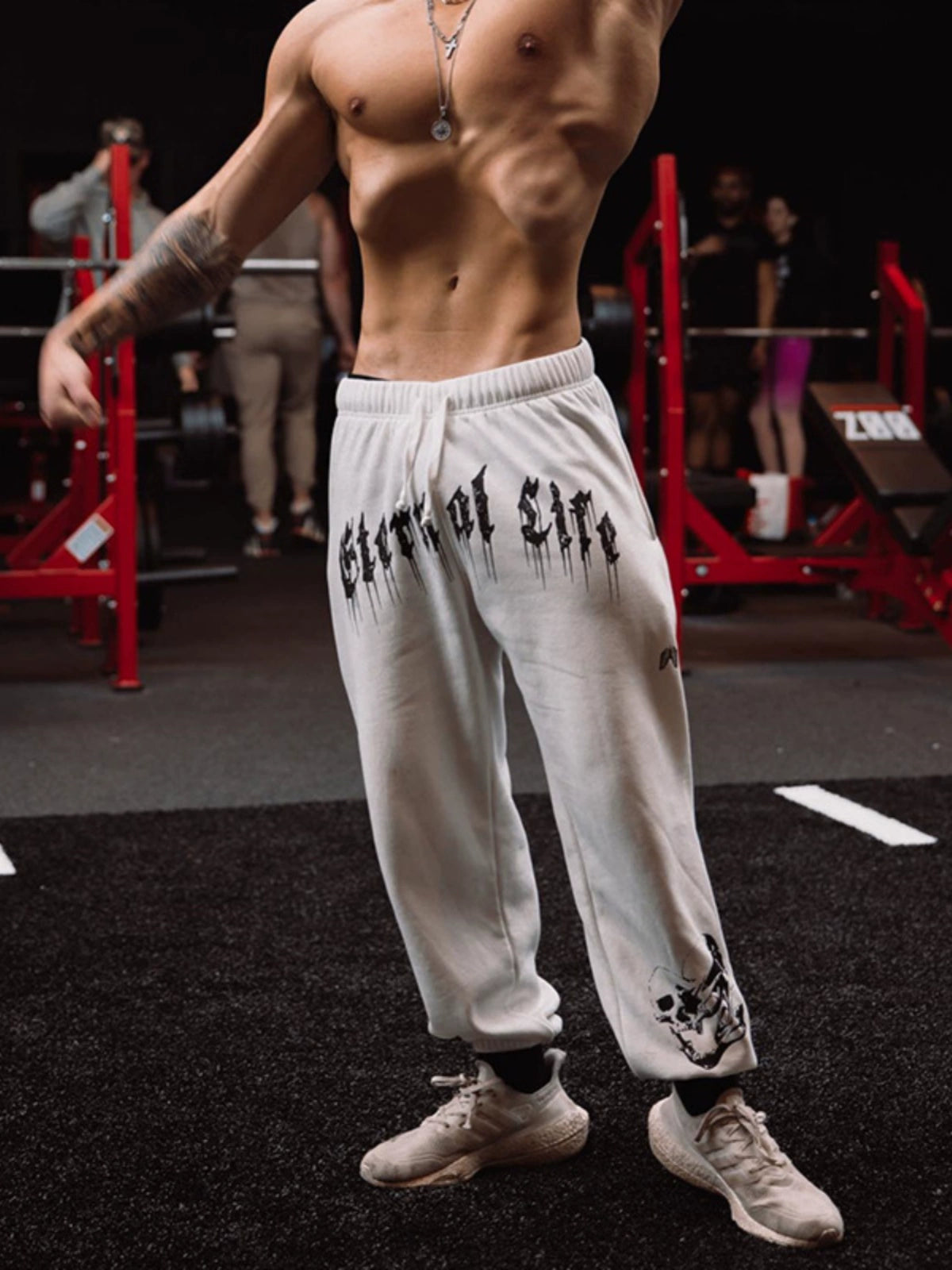 Pantalones deportivos holgados con estampado de calaveras oscuras y tobillos atados para entrenamiento muscular.