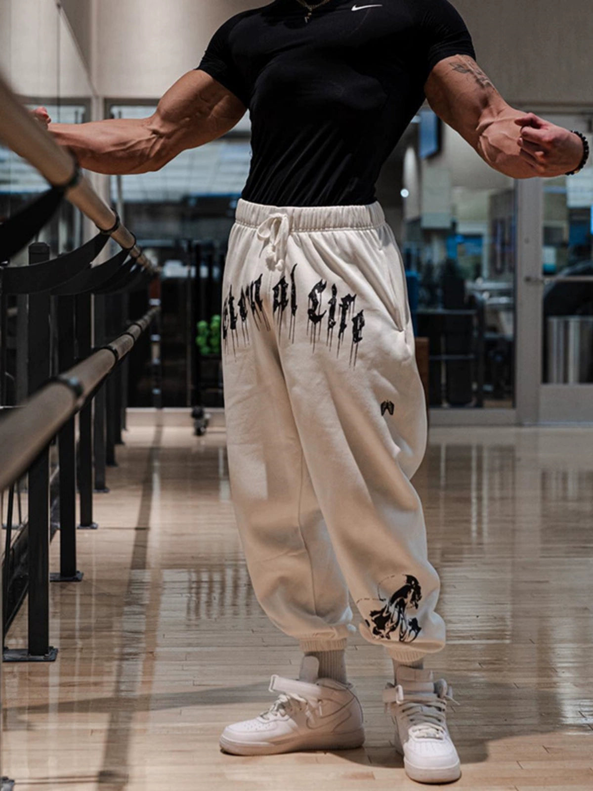 Pantalones deportivos holgados con estampado de calaveras oscuras y tobillos atados para entrenamiento muscular.